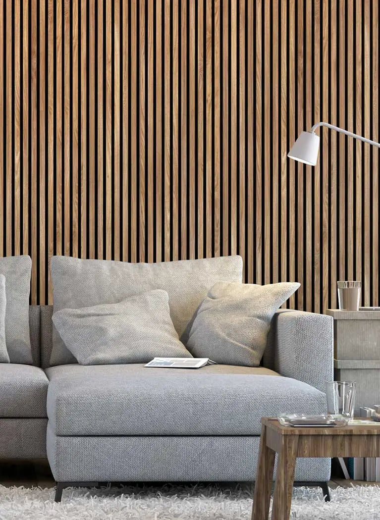 Gray sectional sofa in a living room with wooden slat wall and side table.